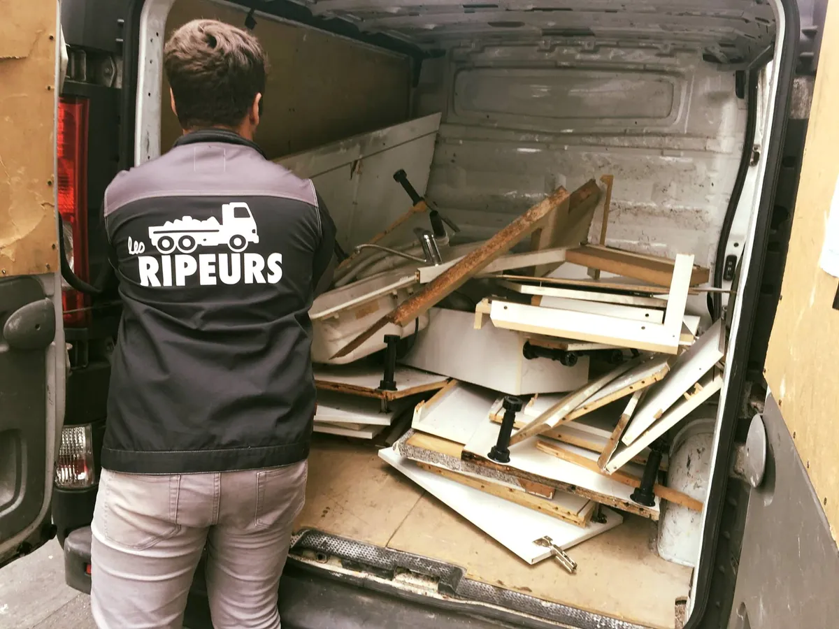 Ripeur de dos, veste Les Ripeurs, chargeant des meubles de cuisine démontés et un évier dans une camionnette